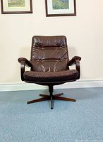 Front view of wine-coloured lounge chair showing tufted leather seat and back, bent plywood frame and star-shaped base