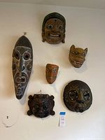 Wide shot of all six masks hanging on wall showing size difference and detail variety