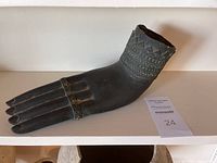 Front view of antique bronze Buddha hand showing detailed finger rings and wrist patterns