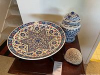Overview of Turkish platter, ginger jar, and brain coral on wood surface near staircase.