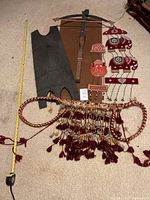 Full overview of the lot showing shield, crossbow, textile piece, and hanging decorative item
