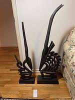 Front view of both Bambara Chiwara wood sculptures showing the two stylized antelope figures with elongated horns and standing on wooden bases.