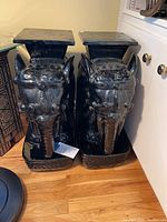 Front view of two black glazed ceramic elephant bases side by side