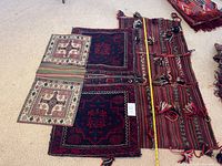 Three saddle bags laid flat on carpet with a tape measure for size reference, showing different weaves and patterns
