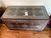Front view of rectangular inlaid wood chest with glass top showing floral medallion pattern and border inlay