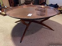 Table assembled showing round copper top resting on wooden stand