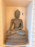 Full front view of seated Buddha figure on lotus-style base