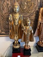 Both statues side by side on stands, front view showing relative heights and overall condition