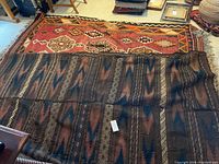 Both rugs layered on floor: clay-colored medallion rug over brown zigzag rug