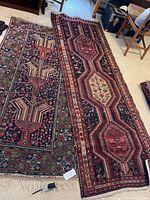 Both tribal runners laid side by side on carpet, full view showing overall pattern and colors of each