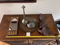 Overall view of the lot showing all five Middle Eastern decorative pieces on wooden cabinet.