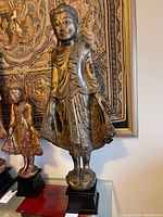 Full front view of statue on black base showing overall height and posture