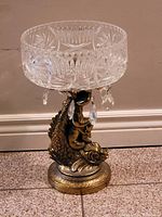 Front view of the crystal candy dish on brass fish base showing detailed cut patterns and hanging crystal prisms