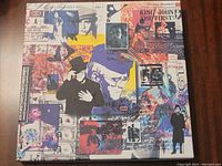 Front cover of hardcover case with colorful collage-style artwork depicting various images of Elton John.
