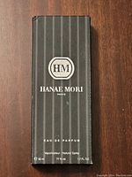 Front of the black, vertically striped Hanae Mori box with fragrance details