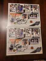 Two 8x11 inch NHL 1993 Wales Conference Starting Lineup promos placed flat on a wood surface, showing multiple player images and autographed by Maurice Richard.