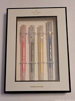 Front view of Kate Spade box showing 4 dual-tipped highlighters in pink, green, yellow, and blue inside transparent case.