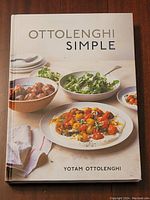Front cover of Ottolenghi Simple cookbook showing plated dishes including salad, meatballs, and tomatoes.