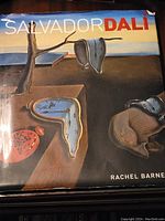 Front cover of the Salvador Dali art book with melting clocks artwork and title by Rachel Barnes.