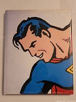 Front cover of Superman The Complete History book showing close-up artwork of Superman's face and costume.