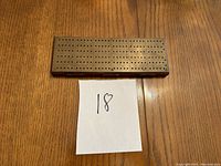 Folded cribbage board showing compact rectangular shape with holes