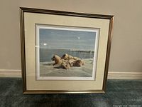 Full view of the framed print showing five dogs resting on snowy ice near water.