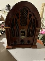 Front view of vintage GE cathedral style radio showing wooden arched case and grille design.