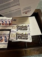 Vintage NHL ticket stubs and laminated memorabilia cards arranged on a wooden surface