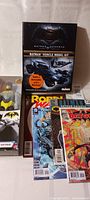Photo showing Batman Vehicle Model Kit in box featuring Batmobile and Batwing, DC Comics including Batman and Robin, and a new in box Batman figure.