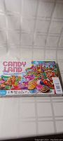 Front of Candy Land boardgame box showing colorful candy-themed illustration and age 3+ indication