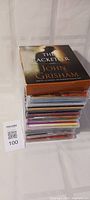 Stack of CDs topped with John Grisham audiobook 'The Racketeer'