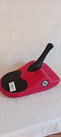 Photo showing red Zipfy sled with black handle and foot grip area, model 05 decal visible.
