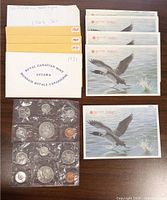 Photo of 12 Royal Canadian Mint proof-like six-coin mint sets in original envelopes and illustrated card holders.