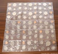 Photo showing all 15 Canadian 6-coin Proof-Like Mint Sets arranged in three rows of five each, coins encased in clear protective plastic sleeves, surface reflecting light showing shine on coins.