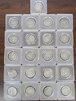 Top view of 21 Canadian 50 cent coins arranged in clear protective holders.