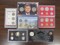 Lot of 7 sets of U.S. coins in plastic holders showing various coins including Kennedy half dollar and Buffalo Nickels.