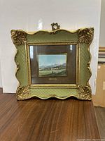 Full view of framed miniature oil painting showing rural landscape with snow covered mountains