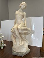 Front view of alabaster Diana statue seated on rock base