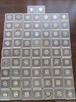 Top-down view of all 63 Canadian 5 cent coins individually encased in plastic holders, arranged in rows on a flat surface.