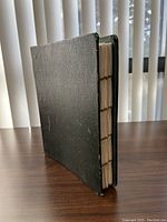 Green vinyl binder closed, standing upright