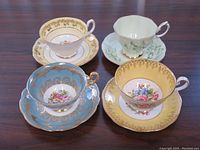 Top view of all four teacup and saucer sets arranged in a square showing colors and patterns