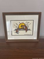 Full view of the framed acrylic painting showing two loons among cattails with a yellow sun in background.