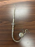 Full view of the elongated silver pipe showing detailed patterns along the stem and the distinctive elephant head at the base.