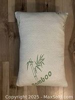 Rectangular cream-colored bamboo pillow with bamboo leaf design.
