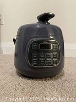 Front view of the Oster rice cooker showing the digital control panel with various cooking functions.