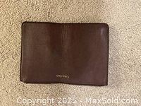 Top view of the brown leather clutch wallet with visible Calvin Klein gold logo