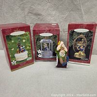 Three boxed Hallmark Keepsake Disney ornaments and one loose Hunchback figure shown for scale against a soda can.