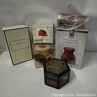 Photo showing all six items packaged or boxed: Jo Malone candle, wax warmer in box, Apple Crisp melts, mouse figurine in envelope box, holiday candle in box, decorative trinket box.