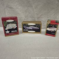 Three boxed Hallmark Keepsake Star Trek ornaments arranged side by side, including USS Defiant, USS Voyager, and Shuttlecraft Galileo, against a neutral background.