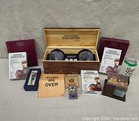 Overview of the lot showing wooden whiskey glass box, whiskey cards, steel chillers, wine bottle stopper, glass coasters, and wine coasters.